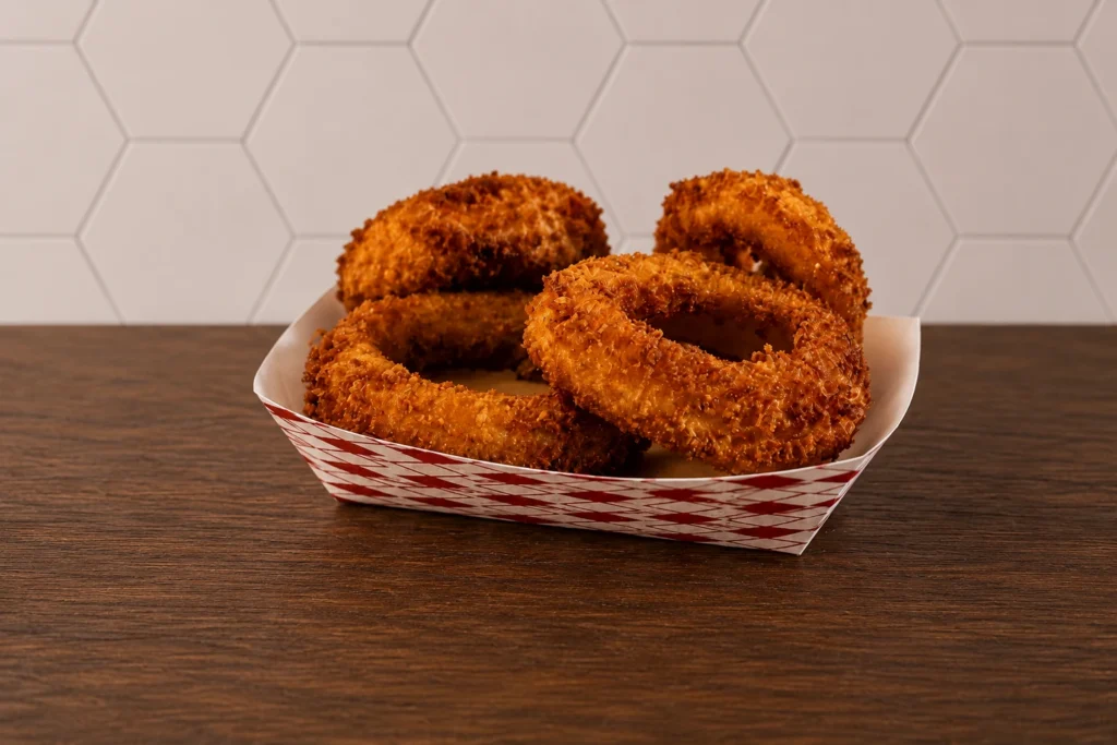 Basket of crispy golden onion rings with a crunchy seasoned coating.